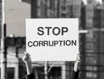 A person holding a sign with Stop Corruption written on it